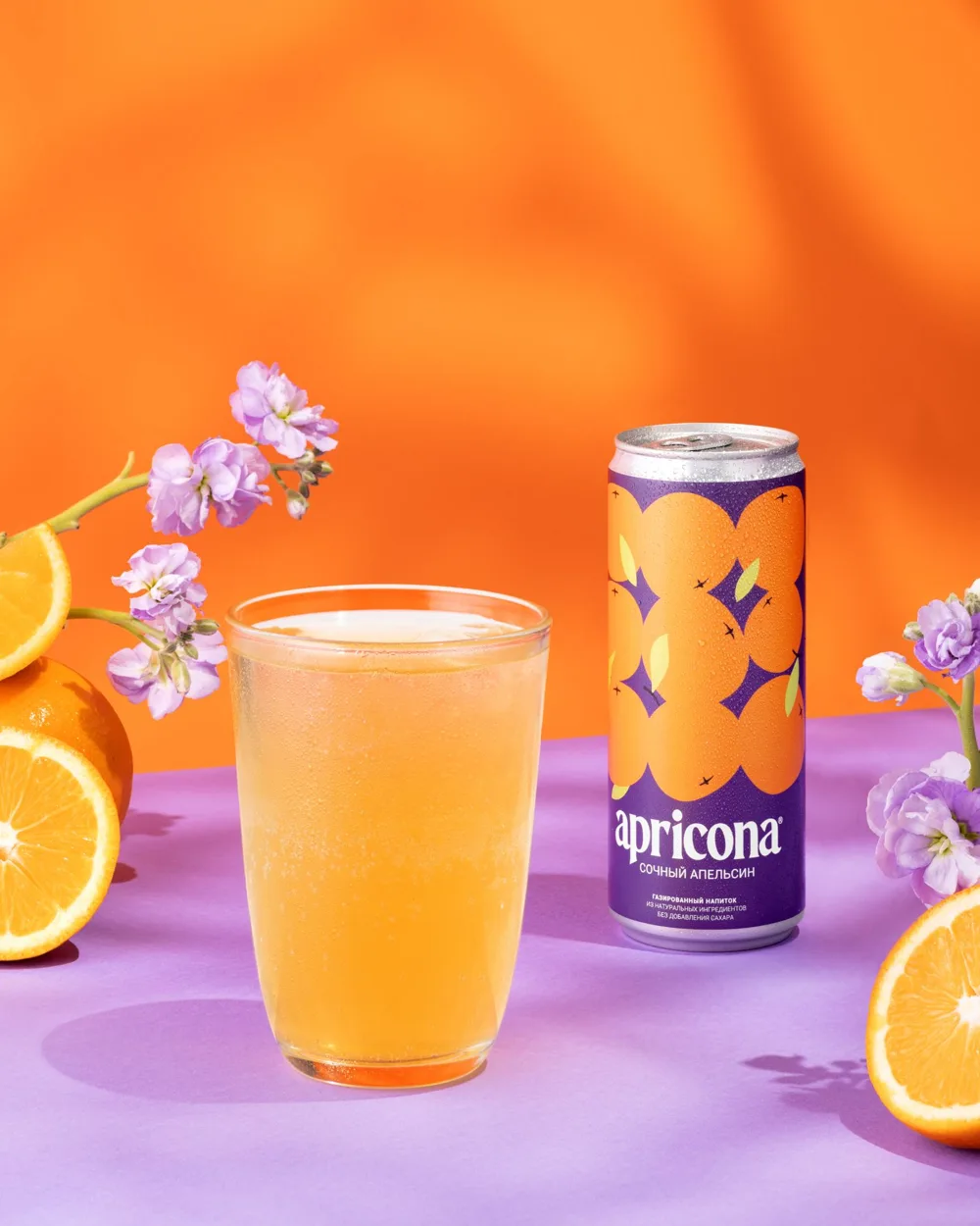 Стакан лимонада и банка Apricona «Сочный апельсин» с дольками апельсина